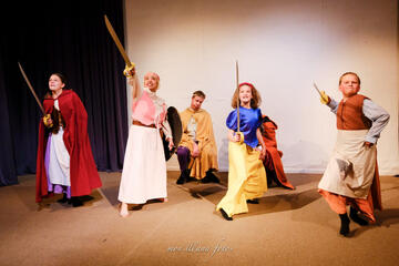 Caryl Loria Illana as Sleeping Beauty in Between the Lines, swordfighting an imaginary dragon with three little girls