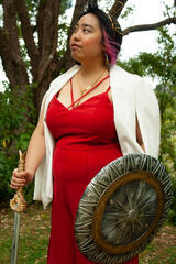 Caryl Loria Illana in a crown, posing with a sword and shield