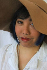 Caryl Loria Illana in a floppy hat which half covers one eye